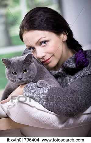 A young woman at home with a British Shorthair cat View Large Photo Image Picture - A young woman at home with a British Shorthair cat. Fotosearch