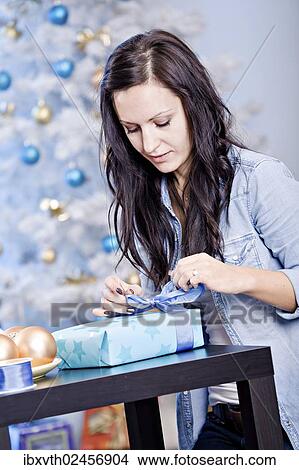 "A young woman wrapping Christmas gifts, Germany, Europe" View Large Photo Image Picture - "A young woman wrapping Christmas gifts, Germany, Europe". Fotosearch