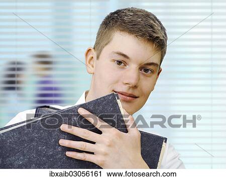 Apprentice or trainee holding files in an office View Large Photo Image Stock Image - Apprentice or trainee holding files in an office. Fotosearch