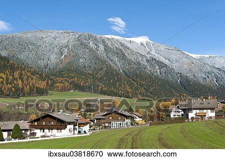Stock Image - "Autumn in the Alps, view over a village towards the autumnal snow-covered forest and Hochnall Mountain, 2337 m, Niederrasen, Rasen-Atholz, Rasun di Sotto, Anterselva, Alto Adige, Trentino-Alto Adige, Italy, Europe". Fotosearch