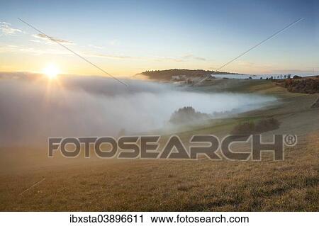 "Autumn mood with mist and sunset on the Alter Postweg in Hegau in Watterdingen, Baden-Wurttemberg, Germany, Europe" View Large Photo Image Stock Image - "Autumn mood with mist and sunset on the Alter Postweg in Hegau in Watterdingen, Baden-Wurttemberg, Germany, Europe". Fotosearch