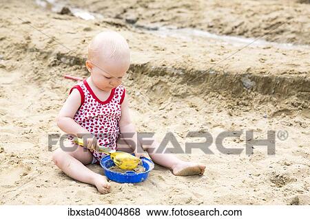 "Baby, 12-14 Months, playing in the sand" View Large Photo Image Stock Photo - "Baby, 12-14 Months, playing in the sand". Fotosearch