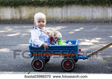 "Baby, 12-14 months, sitting in a handcart" View Large Photo Image Stock Image - "Baby, 12-14 months, sitting in a handcart". Fotosearch