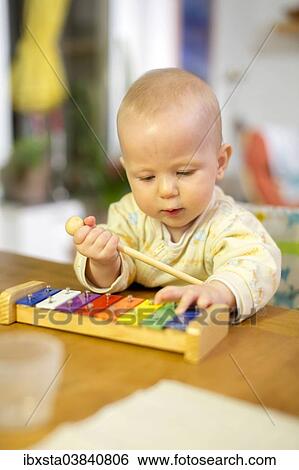Stock Photograph - "Baby, 8 months, playing with a xylophone". Fotosearch