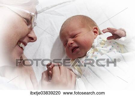 Stock Image - "Baby girl, 2 days, with her mother". Fotosearch