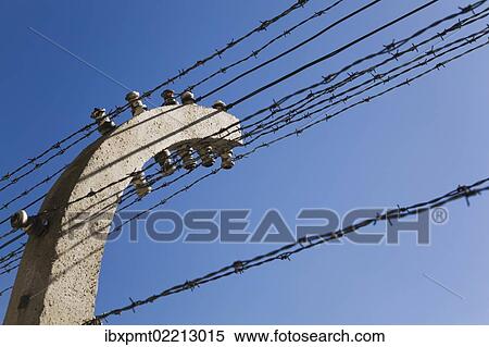 Stock Photography - "Barb wire electric fence inside the Auschwitz I former Nazi Concentration Camp, Auschwitz, Poland, Europe". Fotosearch