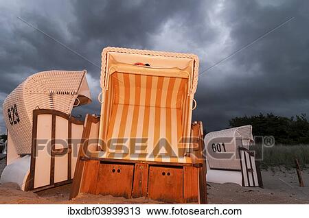 Stock Image - "Beach chairs in the evening light, storm clouds, Baltic Sea, Zingst sea resort, Fischland-Darss-Zingst, Mecklenburg-Western Pomerania, Germany, Europe". Fotosearch
