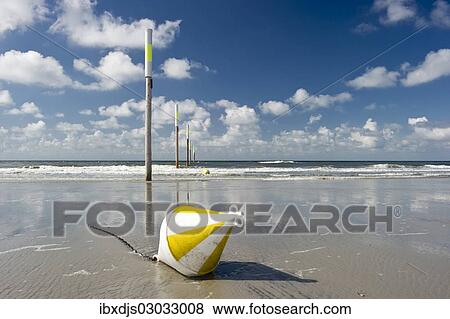 "Beach, marker posts and a buoy, St Peter-Ording, Schleswig-Holstein, Germany, Europe" View Large Photo Image Stock Photo - "Beach, marker posts and a buoy, St Peter-Ording, Schleswig-Holstein, Germany, Europe". Fotosearch