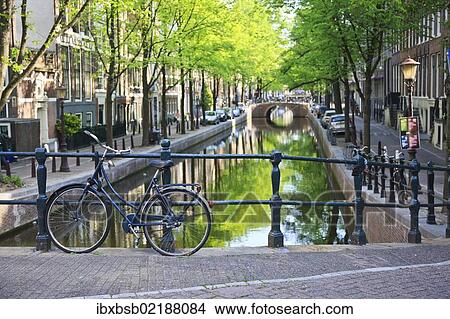 "Bicycle on a bridge crossing a canal in the historic city centre of Amsterdam, Holland, Netherlands, Europe" View Large Photo Image Picture - "Bicycle on a bridge crossing a canal in the historic city centre of Amsterdam, Holland, Netherlands, Europe". Fotosearch