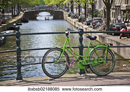 Stock Photography - "Bicycle on a bridge crossing a canal in the historic city centre of Amsterdam, Holland, Netherlands, Europe". Fotosearch