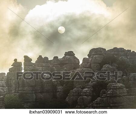 Stock Image - "Bizarre limestone rock formations with the sun and fog, El Torcal Nature Reserve, Antequera, Andalusia, Spain, Europe". Fotosearch
