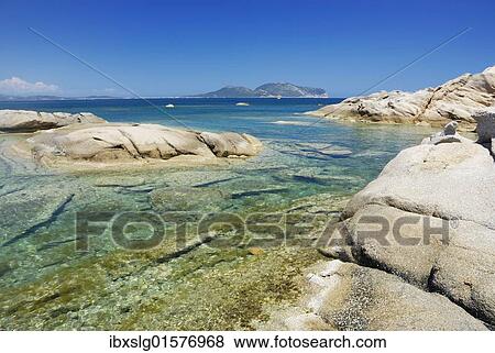 "Bizarre, weathered granite rock boulders in crystal-clear turquoise water at the coast, Capo Ceraso, Sardinia, Italy, Europe" View Large Photo Image Stock Photo - "Bizarre, weathered granite rock boulders in crystal-clear turquoise water at the coast, Capo Ceraso, Sardinia, Italy, Europe". Fotosearch