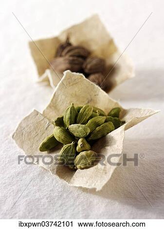 Stock Image - Black and green cardomom seeds. Fotosearch