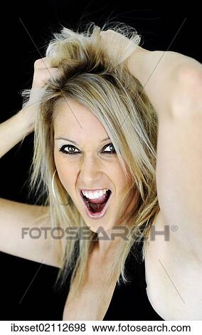 Stock Photo - "Blonde young woman grabbing her hair and screaming, portrait". Fotosearch