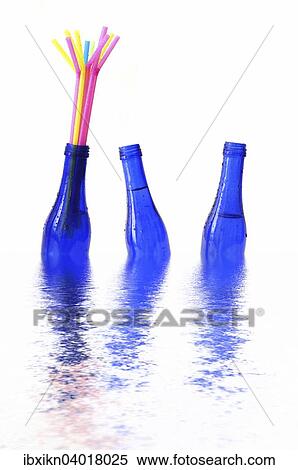 "Blue bottles floating in water, one with coloured straws" View Large Photo Image Stock Photography - "Blue bottles floating in water, one with coloured straws". Fotosearch