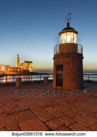 Stock Photograph - "Blue hour, lighthouse, harbour entrance, Gothic Norman Church, Marine Cathedral, Cathedral of San Nicola Pellegrino, 11th century, Trani, Bari province, Apulia, Italy, Europe". Fotosearch