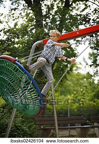 "Boy, 10 years, romping in a playground, swinging in a nest swing" View Large Photo Image Picture - "Boy, 10 years, romping in a playground, swinging in a nest swing". Fotosearch