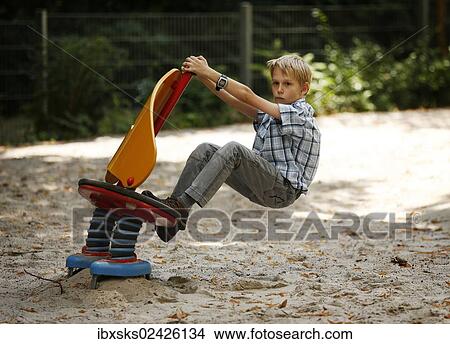 "Boy, 10 years, romping in a playground, sitting on a rocking animal" View Large Photo Image Picture - "Boy, 10 years, romping in a playground, sitting on a rocking animal". Fotosearch
