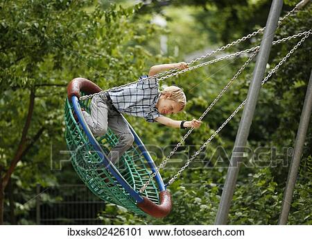 "Boy, 10 years, romping in a playground, swinging in a nest swing" View Large Photo Image Stock Image - "Boy, 10 years, romping in a playground, swinging in a nest swing". Fotosearch