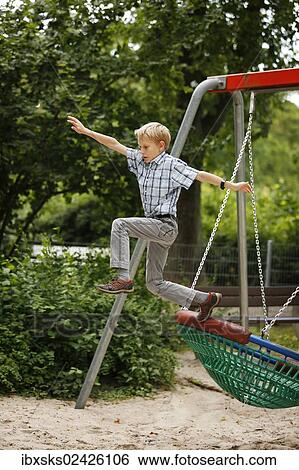 "Boy, 10 years, romping in a playground, jumping out of a nest swing" View Large Photo Image Stock Photograph - "Boy, 10 years, romping in a playground, jumping out of a nest swing". Fotosearch