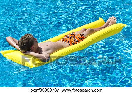 "Boy, 12 years, lying on a lilo in a swimming pool" View Large Photo Image Stock Photo - "Boy, 12 years, lying on a lilo in a swimming pool". Fotosearch