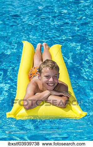 "Boy, 12 years, lying on a lilo in a swimming pool" View Large Photo Image Stock Photo - "Boy, 12 years, lying on a lilo in a swimming pool". Fotosearch