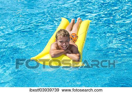 "Boy, 12 years, lying on a lilo in a swimming pool" View Large Photo Image Stock Photo - "Boy, 12 years, lying on a lilo in a swimming pool". Fotosearch