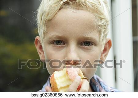 Boy eating an apple View Large Photo Image Stock Photograph - Boy eating an apple. Fotosearch