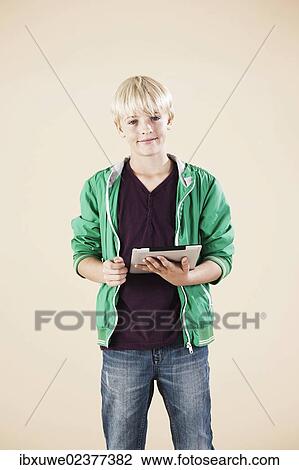 Stock Image - Boy holding a digital tablet. Fotosearch