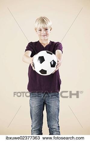 Stock Image - Boy holding a football. Fotosearch