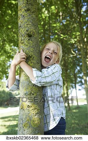 "Boy hugging a tree trunk, screaming" View Large Photo Image Stock Photo - "Boy hugging a tree trunk, screaming". Fotosearch