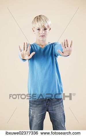 "Boy in a blue sweater and jeans, defensive gesture" View Large Photo Image Stock Photograph - "Boy in a blue sweater and jeans, defensive gesture". Fotosearch