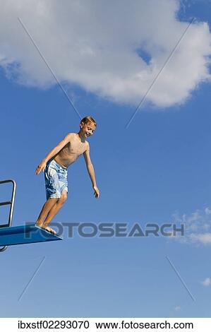 Boy jumping from the three-metre diving board at an outdoor swimming pool View Large Photo Image Stock Image - Boy jumping from the three-metre diving board at an outdoor swimming pool. Fotosearch
