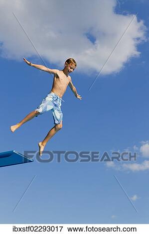 Boy jumping from the three-metre diving board at an outdoor swimming pool View Large Photo Image Stock Photo - Boy jumping from the three-metre diving board at an outdoor swimming pool. Fotosearch