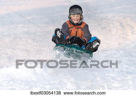 Boy jumping with a sledge View Large Photo Image Stock Photo - Boy jumping with a sledge. Fotosearch
