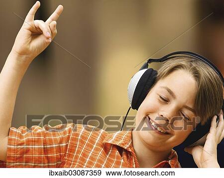 Stock Photo - Boy listening to music with headphones. Fotosearch