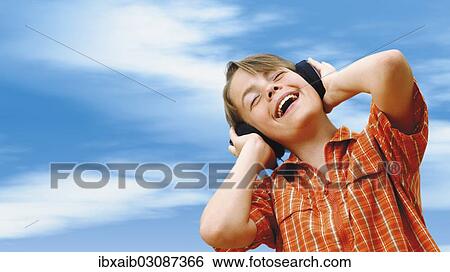 Stock Photograph - Boy listening to music with headphones. Fotosearch