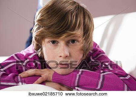 Boy lying on a couch with a contemplative expression View Large Photo Image Stock Image - Boy lying on a couch with a contemplative expression. Fotosearch