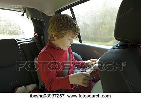 Boy reading in the car View Large Photo Image Stock Photo - Boy reading in the car. Fotosearch