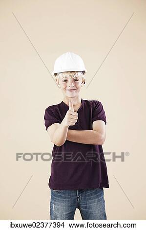 Picture - "Boy with a hard hat, making thumbs up gesture". Fotosearch