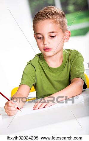 Stock Photography - Boy with a sketch-pad at a table. Fotosearch