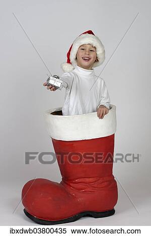 Boy with small gift in a Christmas boot View Large Photo Image Stock Photography - Boy with small gift in a Christmas boot. Fotosearch