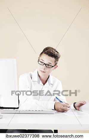 Stock Photo - Boy working on a computer at his desk. Fotosearch