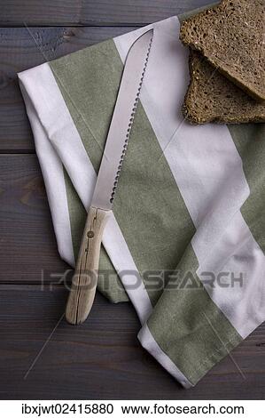 Bread knife and slices of bread with a kitchen towel on a wooden background View Large Photo Image Stock Image - Bread knife and slices of bread with a kitchen towel on a wooden background. Fotosearch