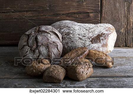 Bread loaves and rolls on a rustic wooden surface View Large Photo Image Stock Image - Bread loaves and rolls on a rustic wooden surface. Fotosearch