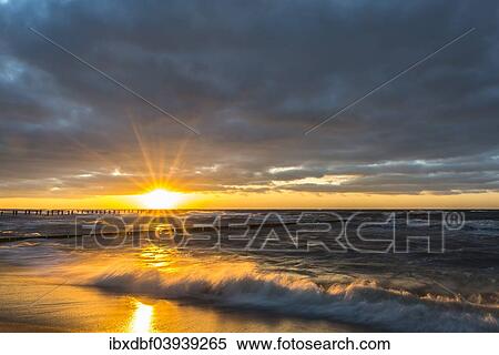 "Breakwaters or groynes, sunset, storm clouds, breaking wave, evening light, Baltic Sea, Fischland-Darss-Zingst peninsula, Mecklenburg-Western Pomerania, Germany, Europe" View Large Photo Image Stock Photography - "Breakwaters or groynes, sunset, storm clouds, breaking wave, evening light, Baltic Sea, Fischland-Darss-Zingst peninsula, Mecklenburg-Western Pomerania, Germany, Europe". Fotosearch