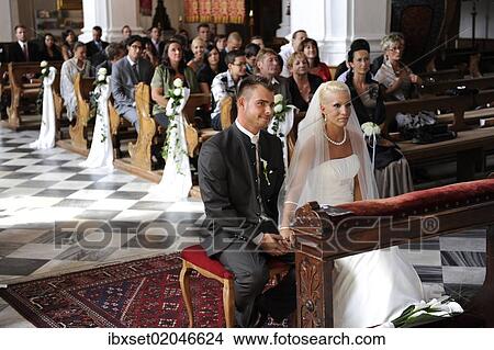 Bridal couple sitting in church in front of the wedding party View Large Photo Image Picture - Bridal couple sitting in church in front of the wedding party. Fotosearch