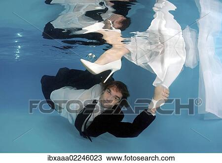 Stock Image - "Bridal couple, underwater wedding in pool, Odessa, Ukraine, Eastern Europe, Europe". Fotosearch