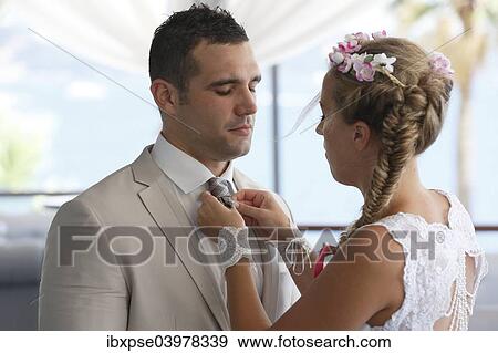 Stock Photo - Bride adjusting the groom's tie. Fotosearch