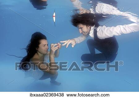 Stock Photo - "Bride and groom, exchanging rings, underwater wedding in pool, Odessa, Ukraine, Eastern Europe, Europe". Fotosearch